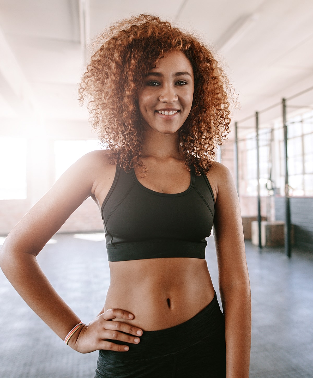Smiling woman in activewear, fitness setting.