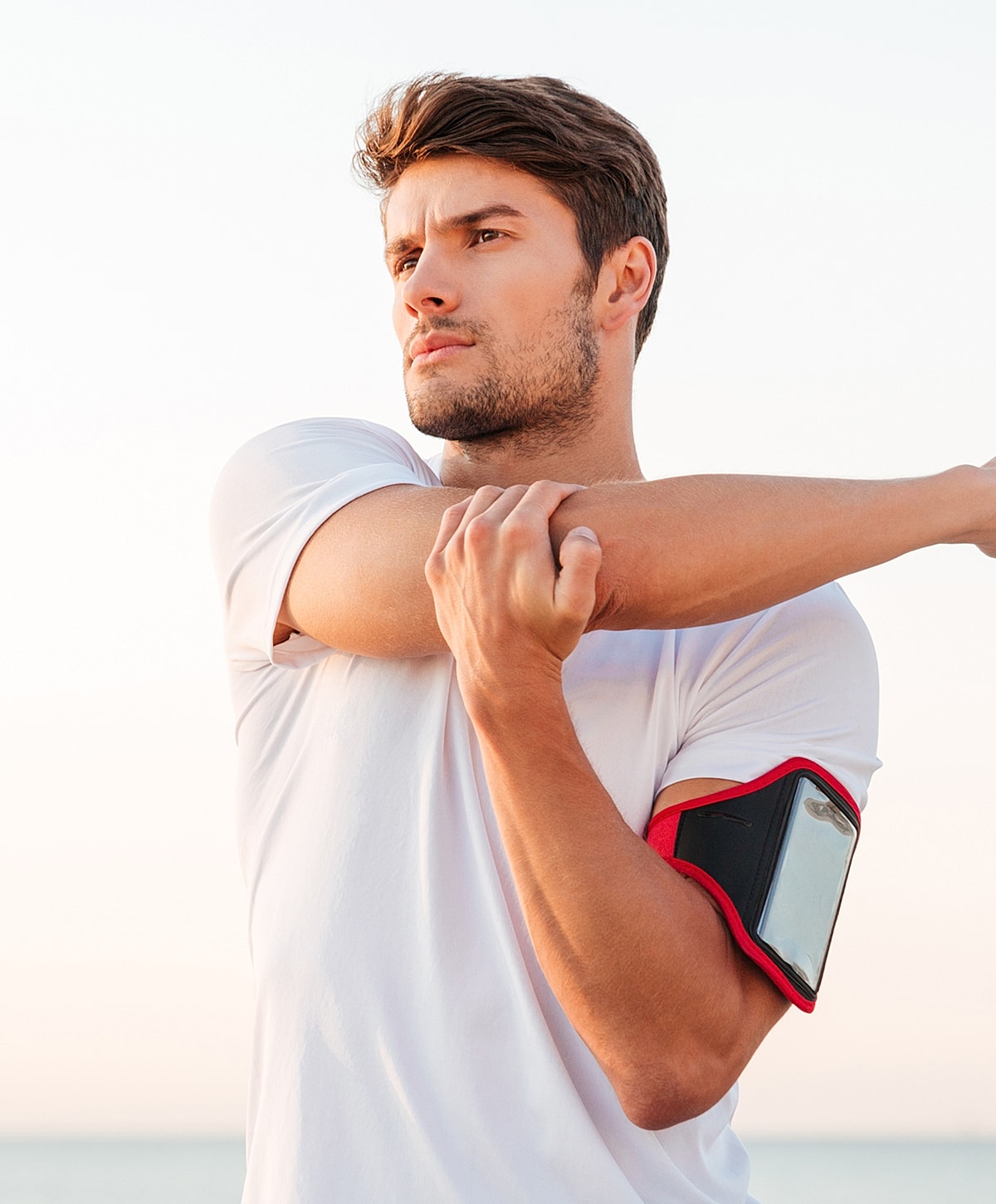 Athlete stretching before exercise outdoors at sunset.