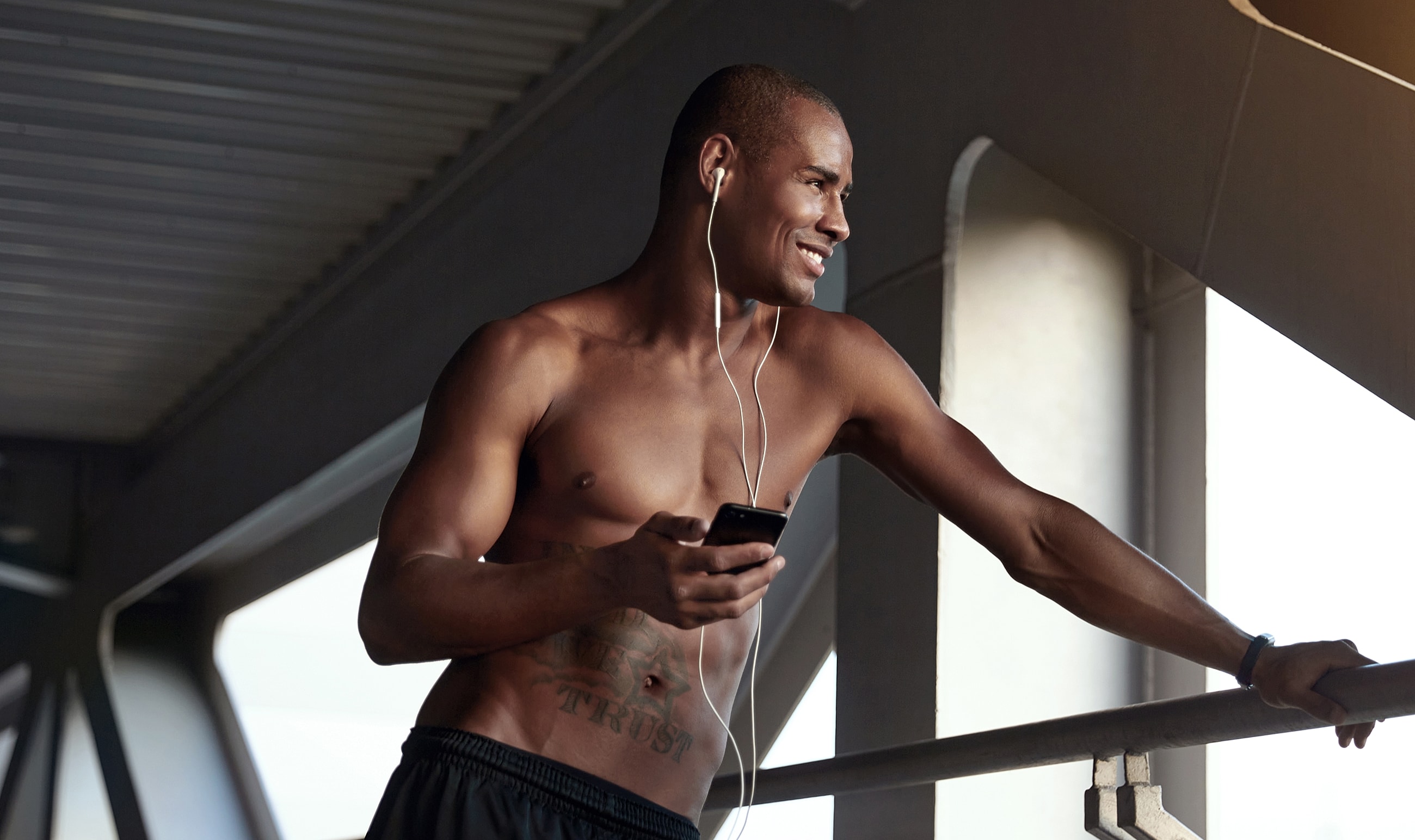 Man listening to music while using smartphone outdoors.